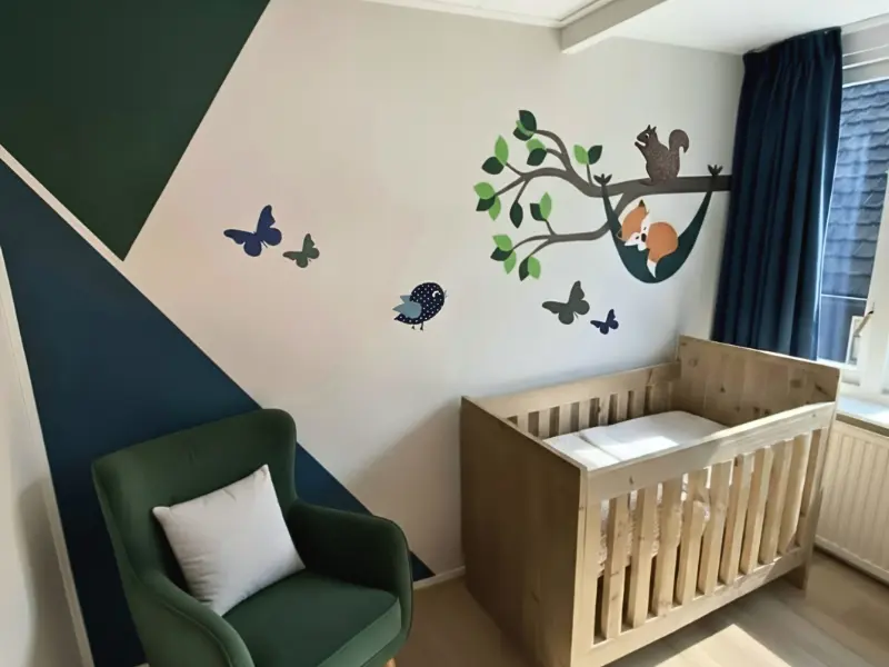 Groene jongens babykamer met muurdecoratie in donkerblauw en donkergroen